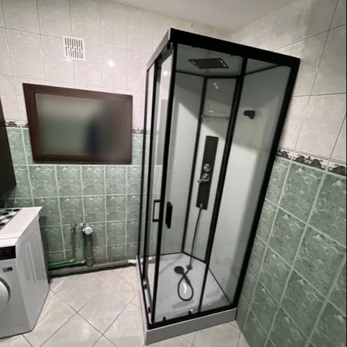 Łazienka z czarną kabiną prysznicową i pralką — DobryHydraulik Białystok